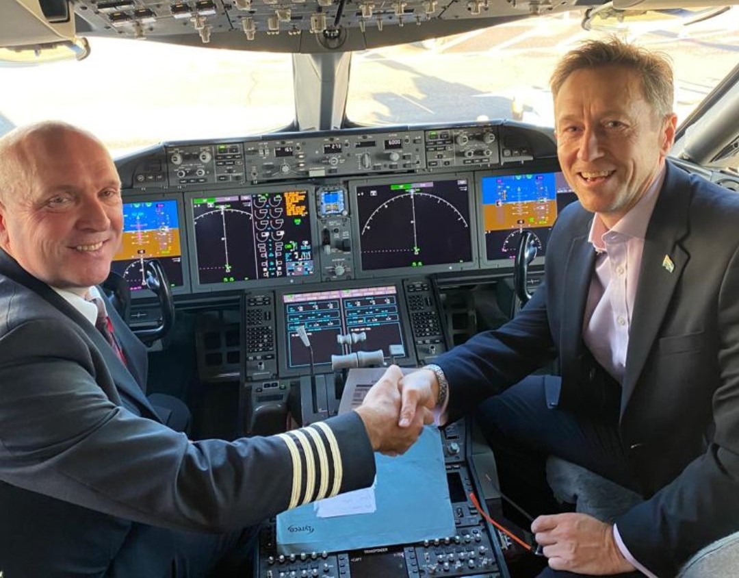 Civil Aviation Authority CEO Rob Bishton shaking hands with the pilot in the cockpit of the plane