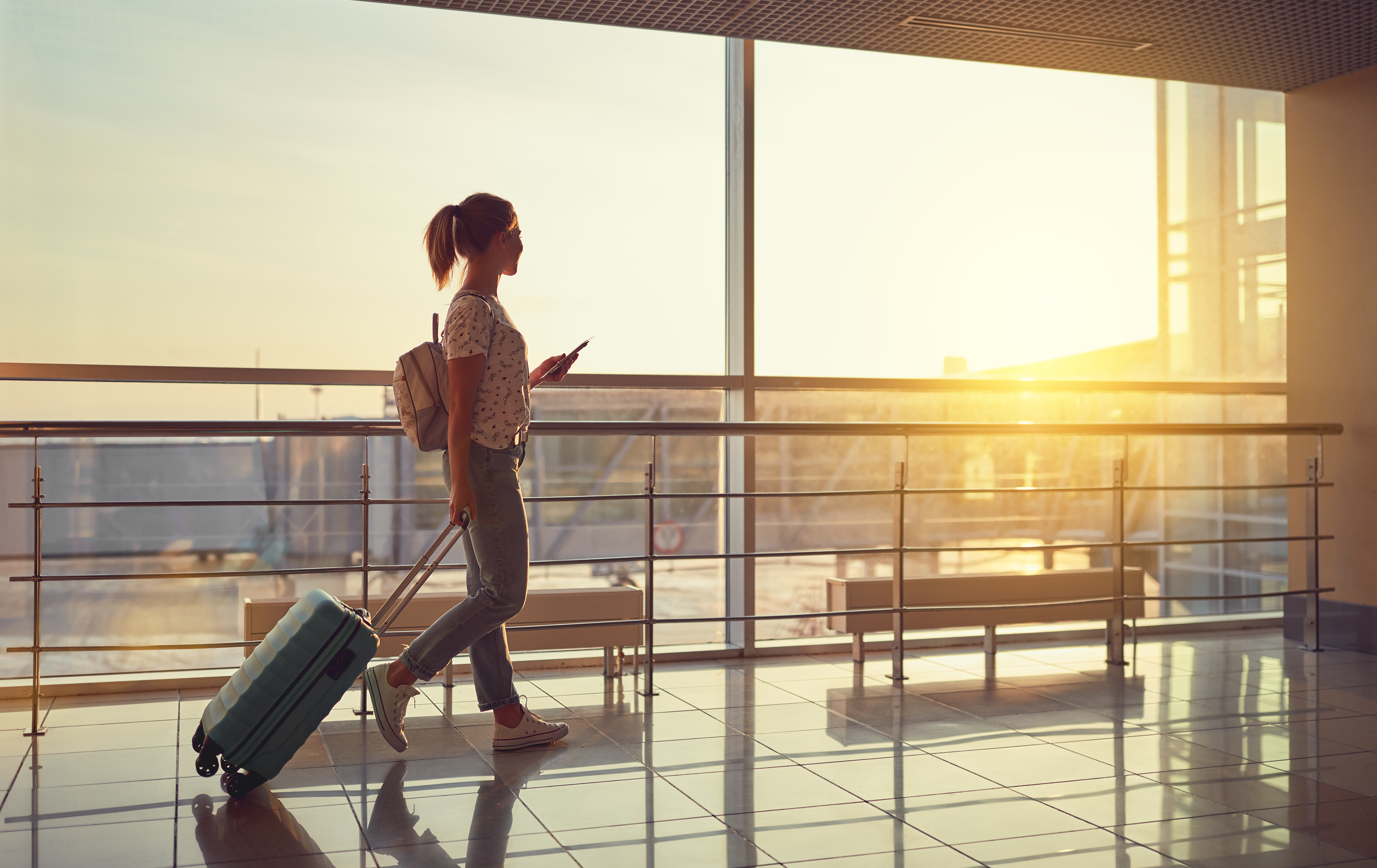 Passenger with holdall walking through airport terminal