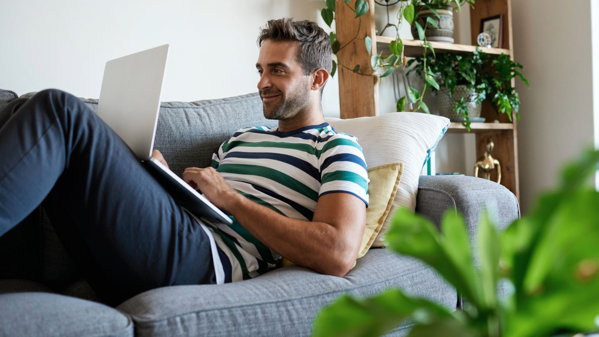 Image of a man smiling looking at laptop