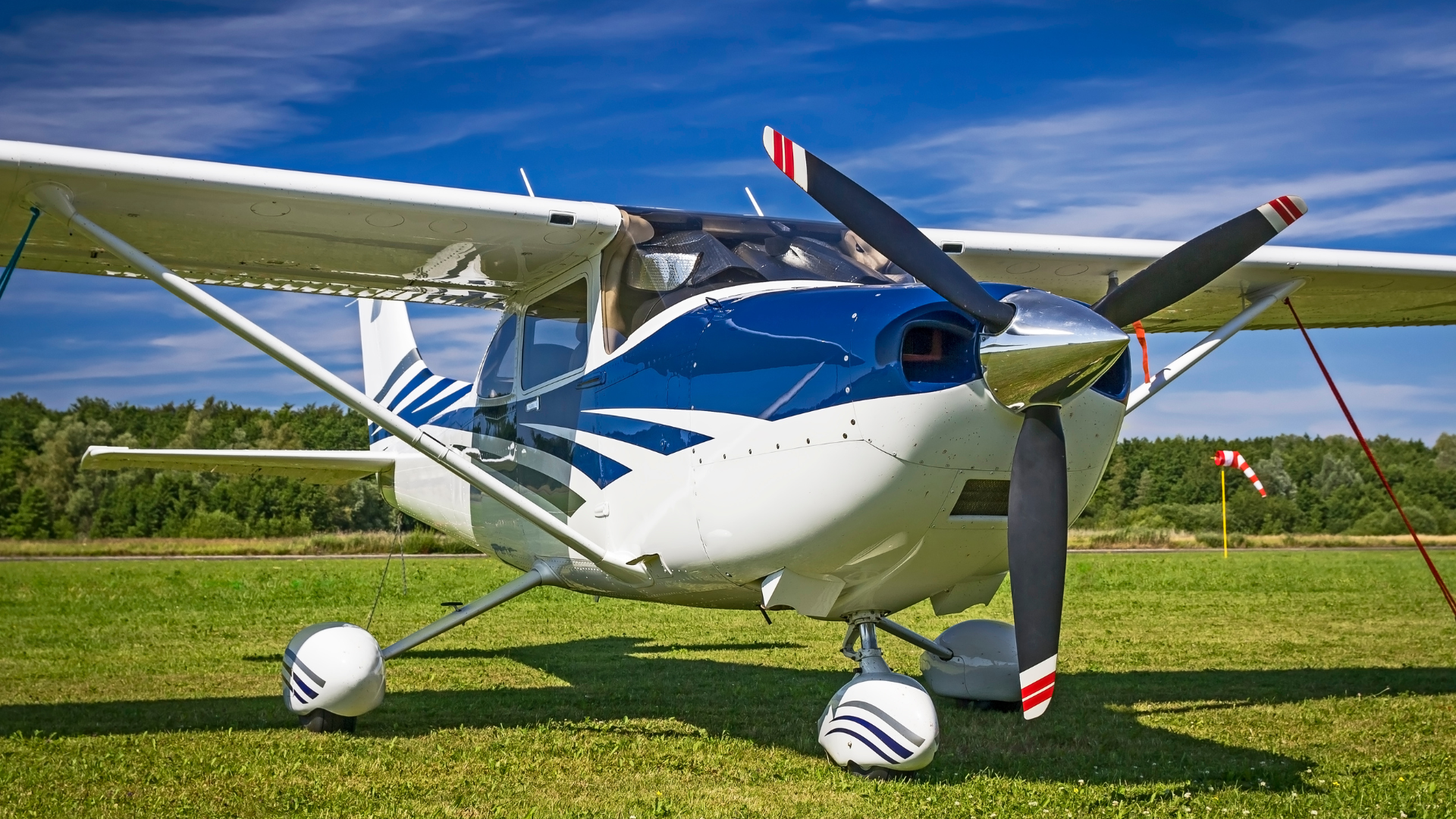 An image of a white coloured light aircraft stationary on the ground.