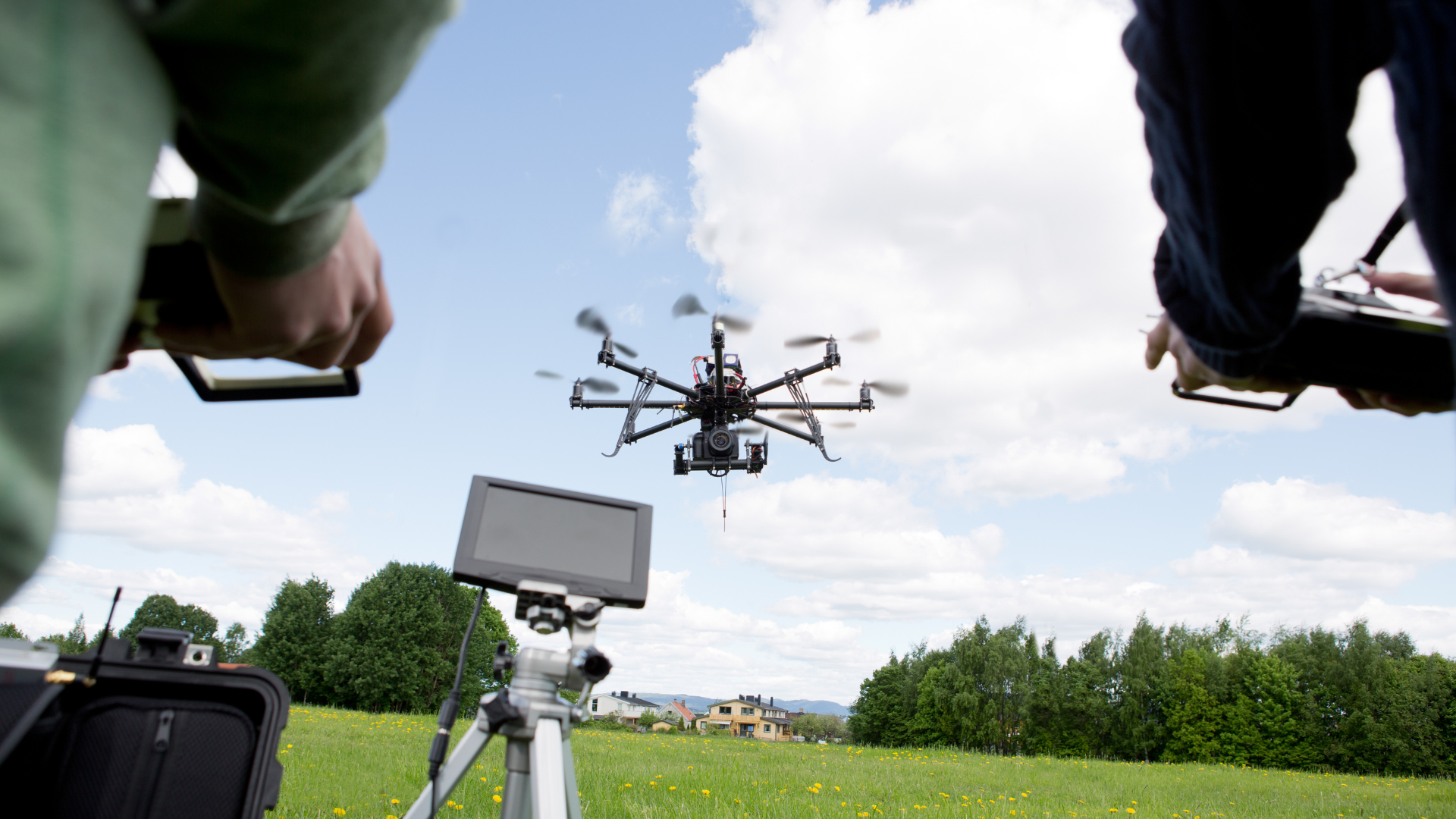 Image of two people controlling a drone